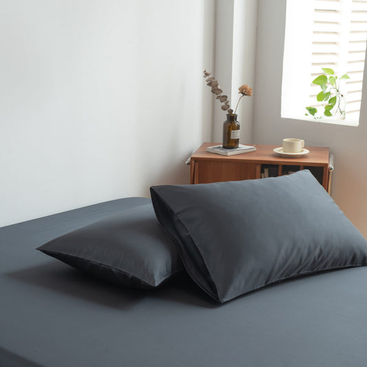 Foto van zijaanzicht van twee kussenslopen Space Blue op een bed (kleur donker blauw)